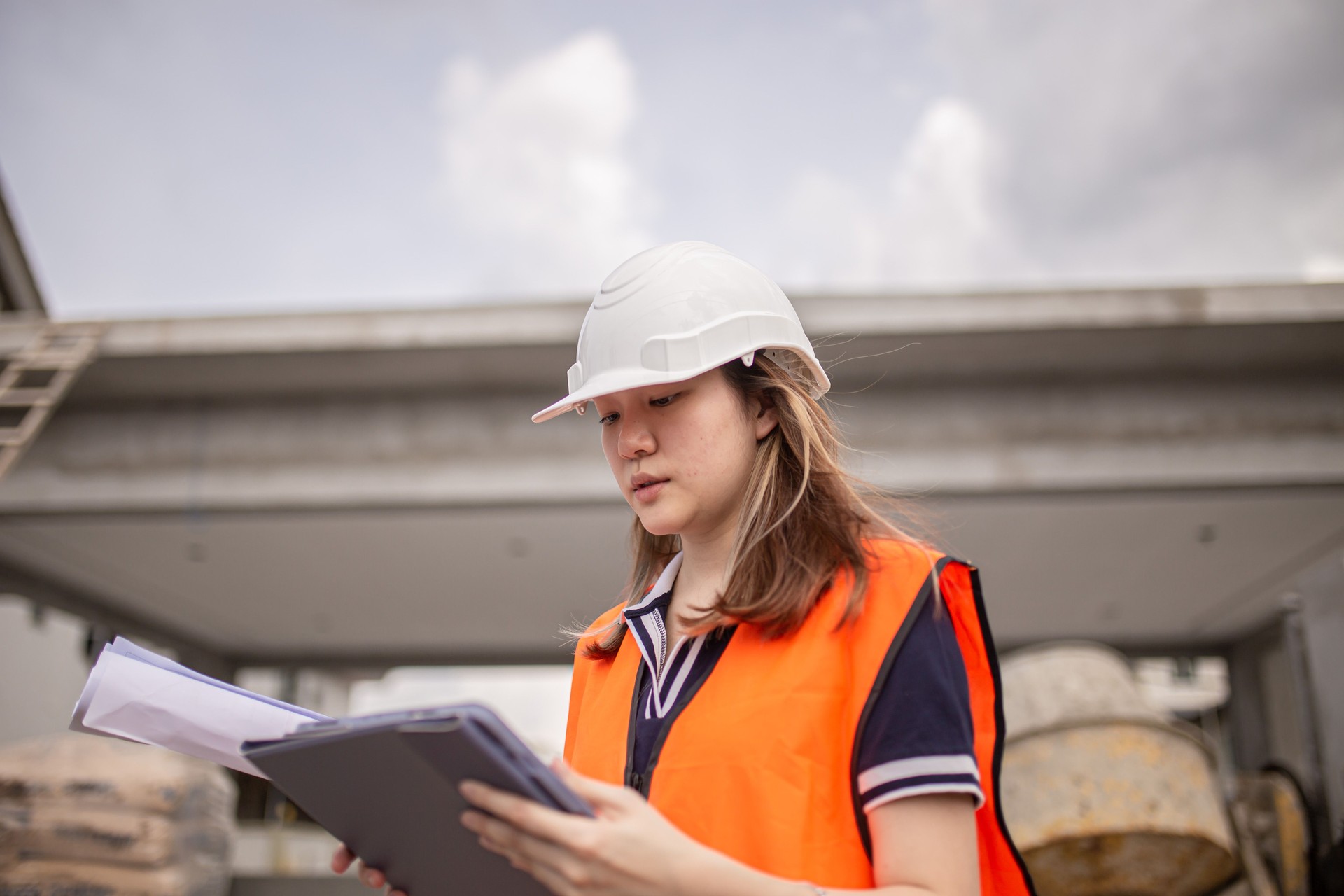 Architetti cinesi asiatici che utilizzano tablet digitale in cantiere