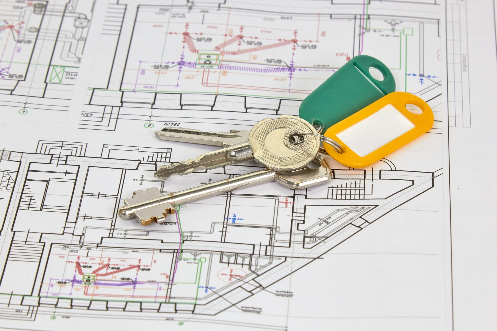 disegni architettonici su un foglio bianco con chiavi della casa, il concetto di costruzione e progettazione di immobili